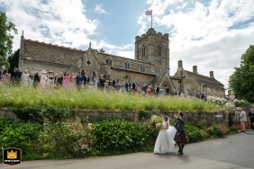 Bride and groom wave to guests leaving the scenic Wing church in Rutland, walking away into their new life.